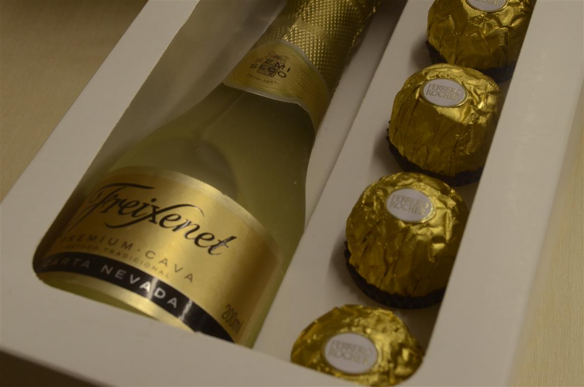 Dicas de embalagens para vinho e espumante: Como presentear com as bebidas queridinhas do inverno? Embalagem em formato de caixa branca com uma garrafa de freixenet e doces ferreiro rocher - dicas de embalagens para vinho